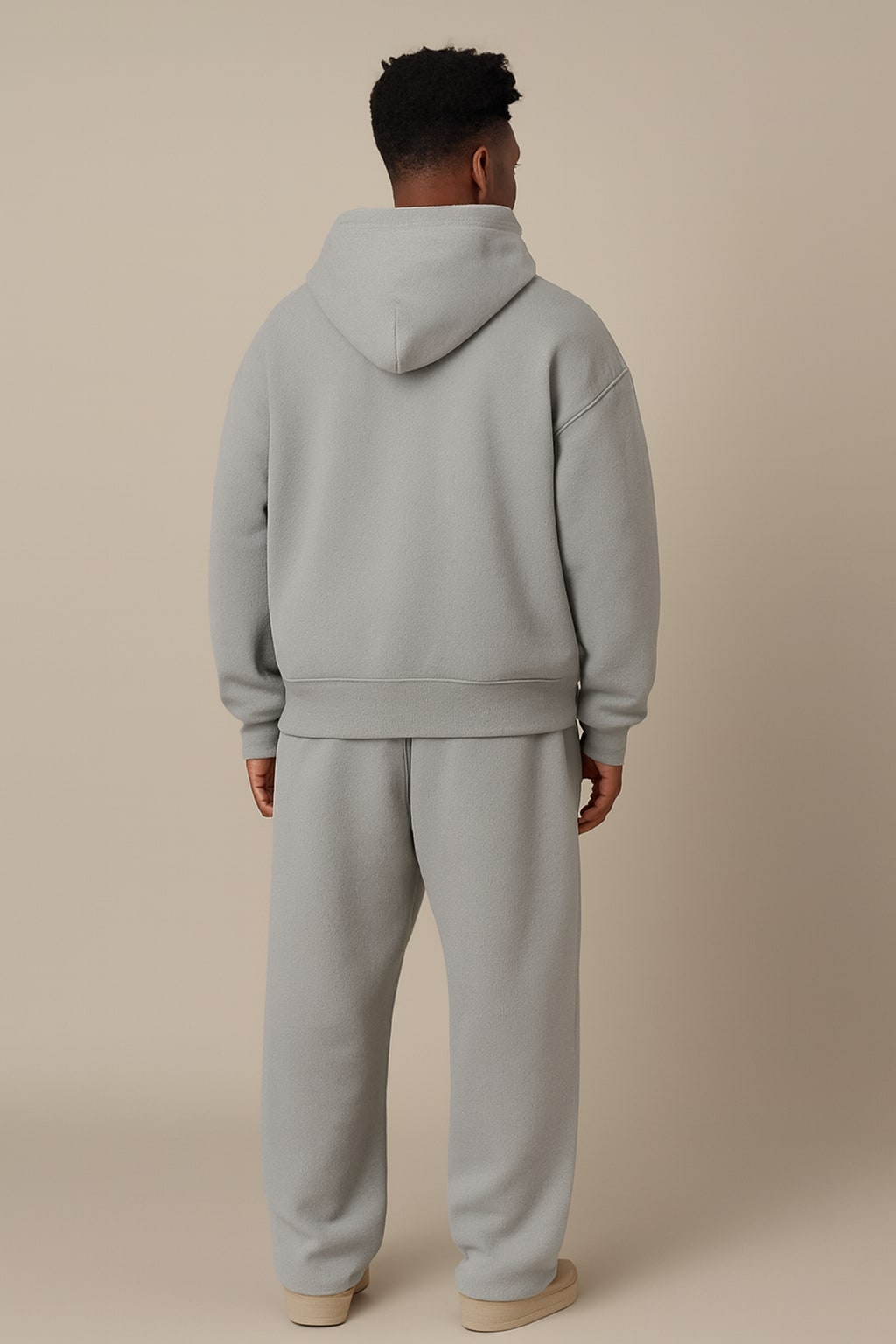 Back view of the men's oversized tracksuit in light grey on a model