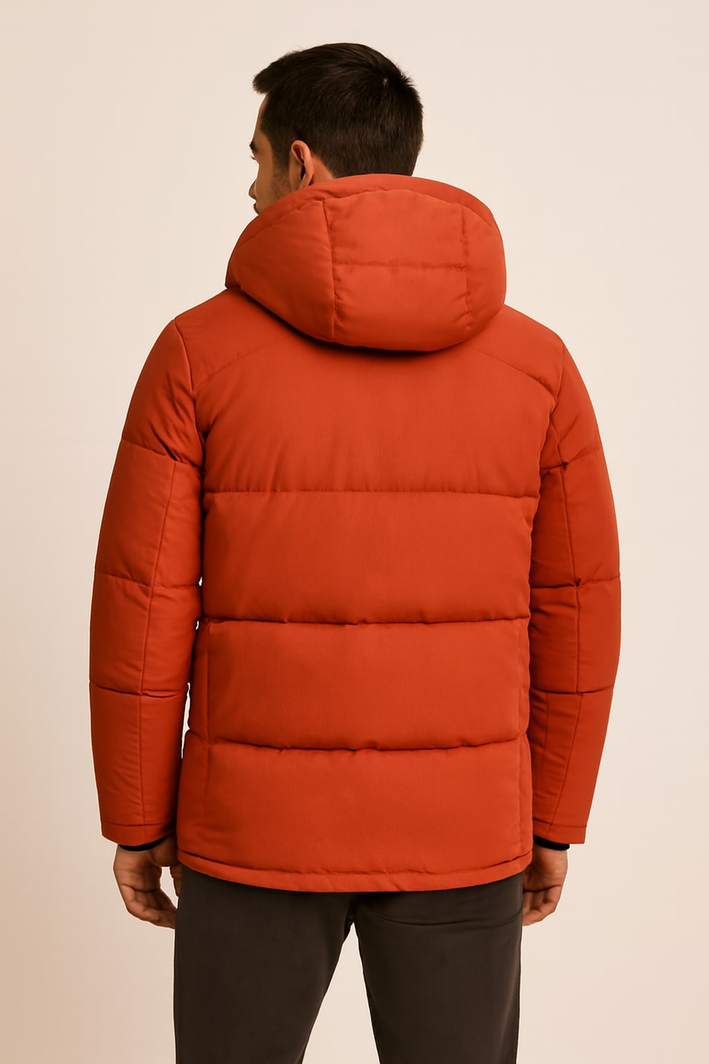 Back view of the men's parka jacket in orange on a model